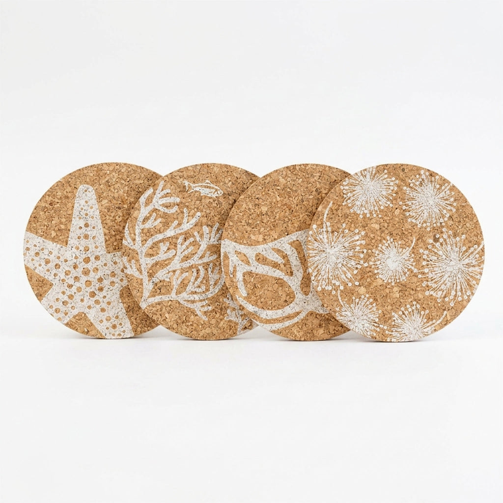 Four round cork coasters with white marine-themed prints, including a starfish, coral, and sea urchins, arranged in a row on a white background from Hem And Tassel 