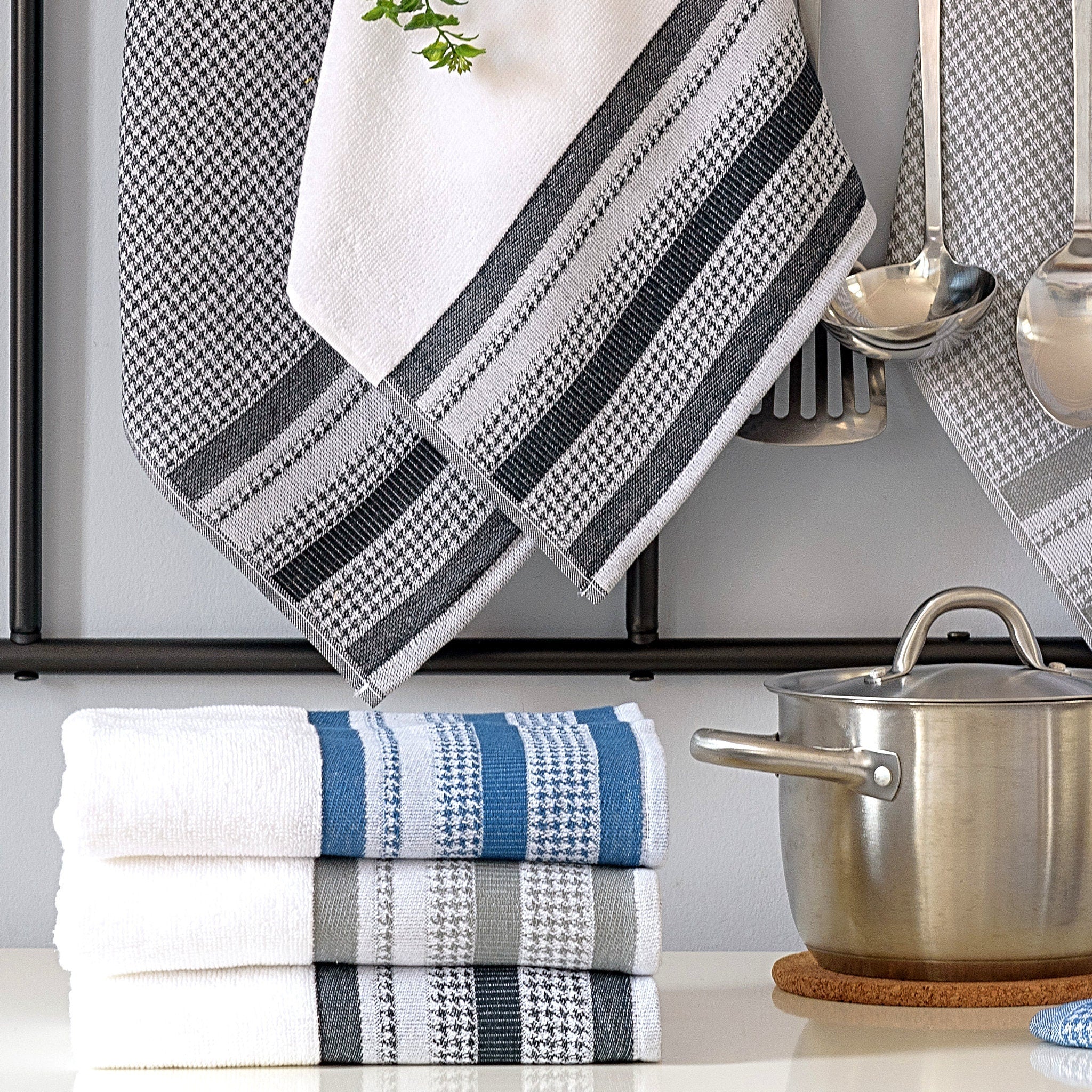 Set of kitchen towels with houndstooth pattern hanging on a rack with pots and utensils from Hem And Tassel 