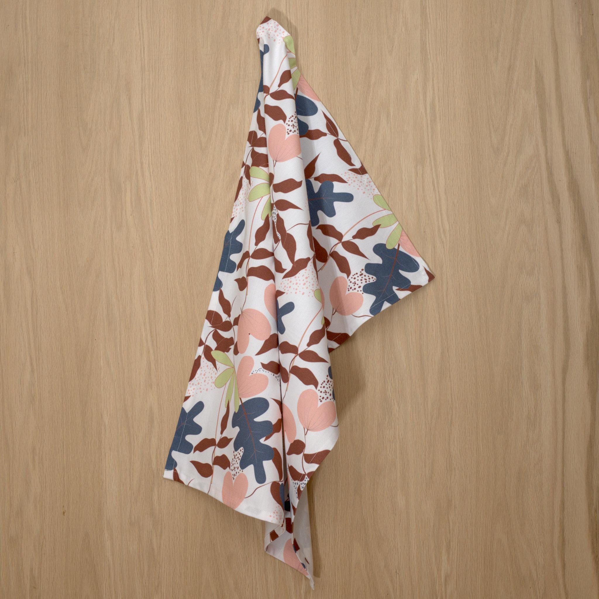 rich cotton percale kitchen towel of just leaves design in oil oak color against a wooden background- from Hem And Tassel