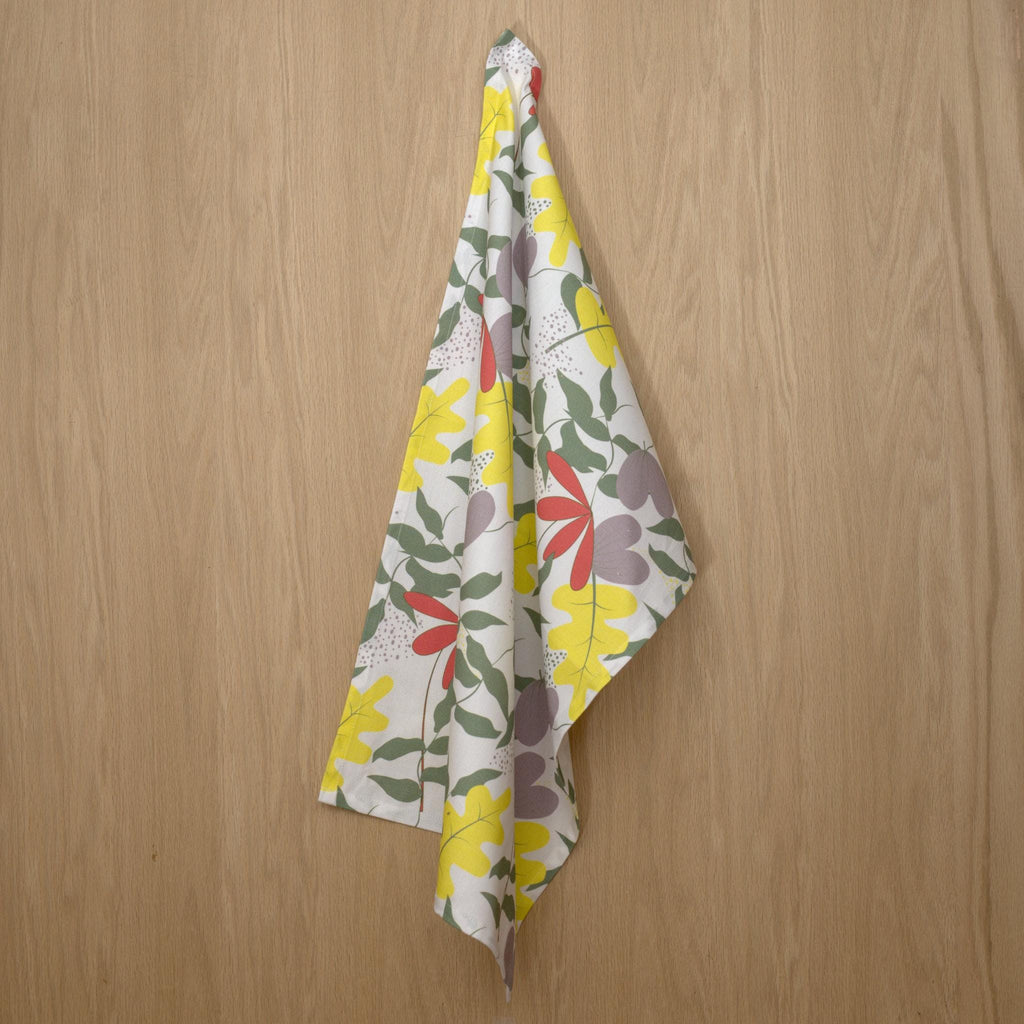 Leaf patterned just leaves tea towel yellow oak hanging on a wooden surface from Hem And Tassel 