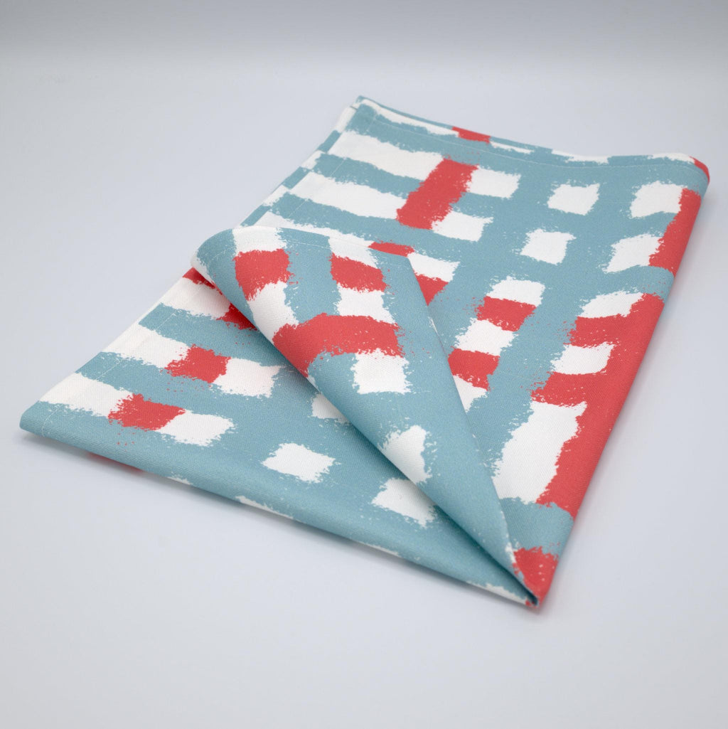 Folded cotton tea towel with blue and pink jute impossible pattern from Hem And Tassel on a gray background