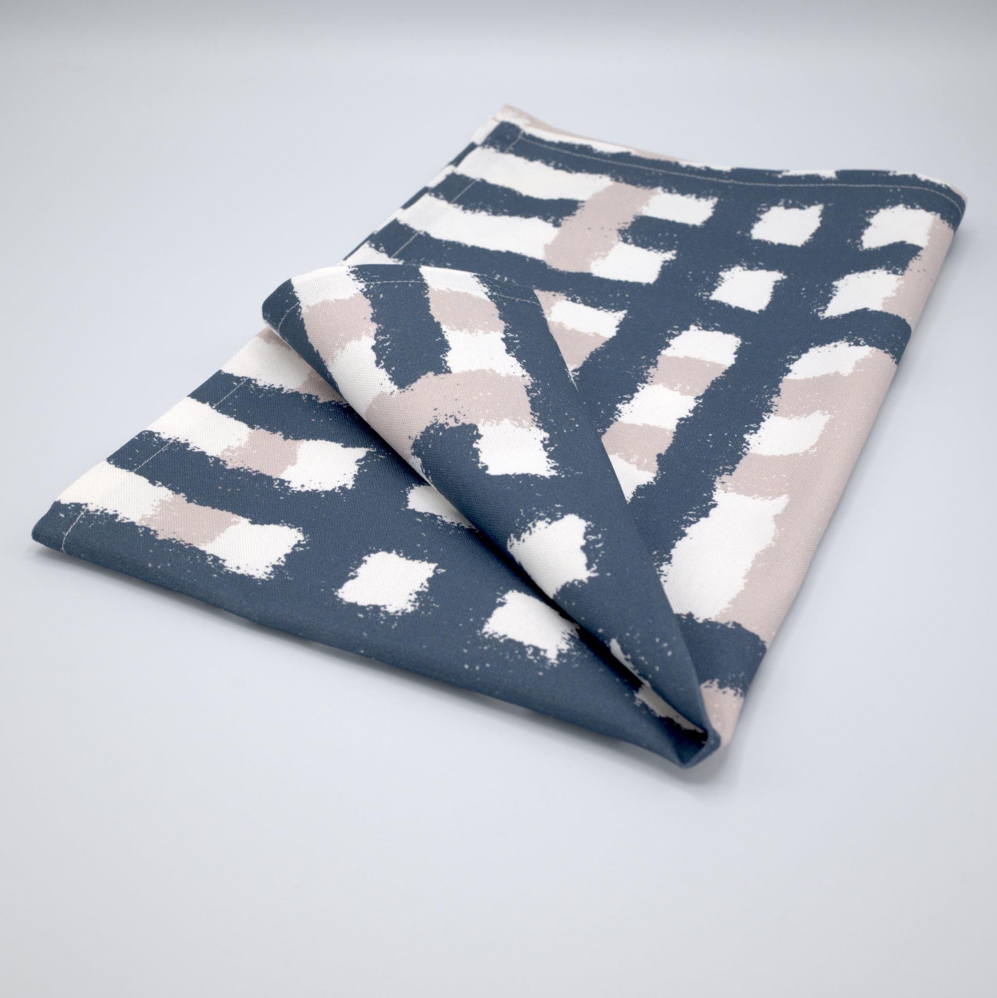 Folded cotton tea towel with oil and slate jute impossible pattern from Hem And Tassel on a gray background