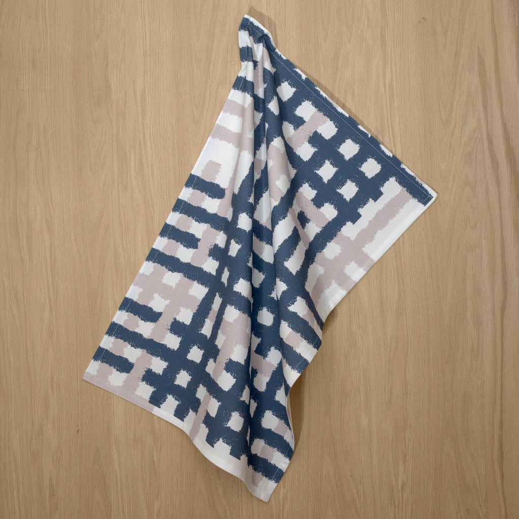 hainging cotton tea towel with oil and slate jute impossible pattern from Hem And Tassel on a wood background