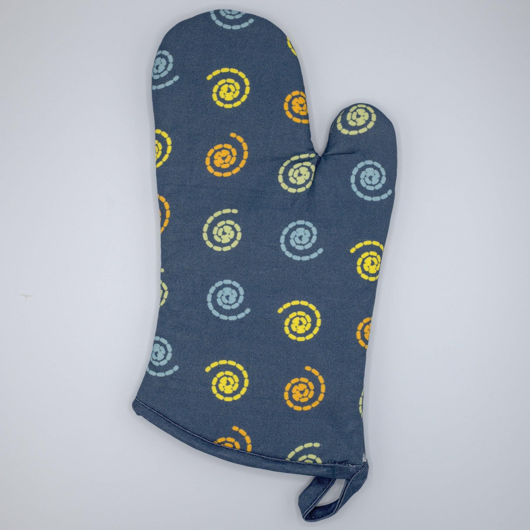 Colorful mushroom magic cotton oven mitt  from Hem And Tassel, on a wooden surface