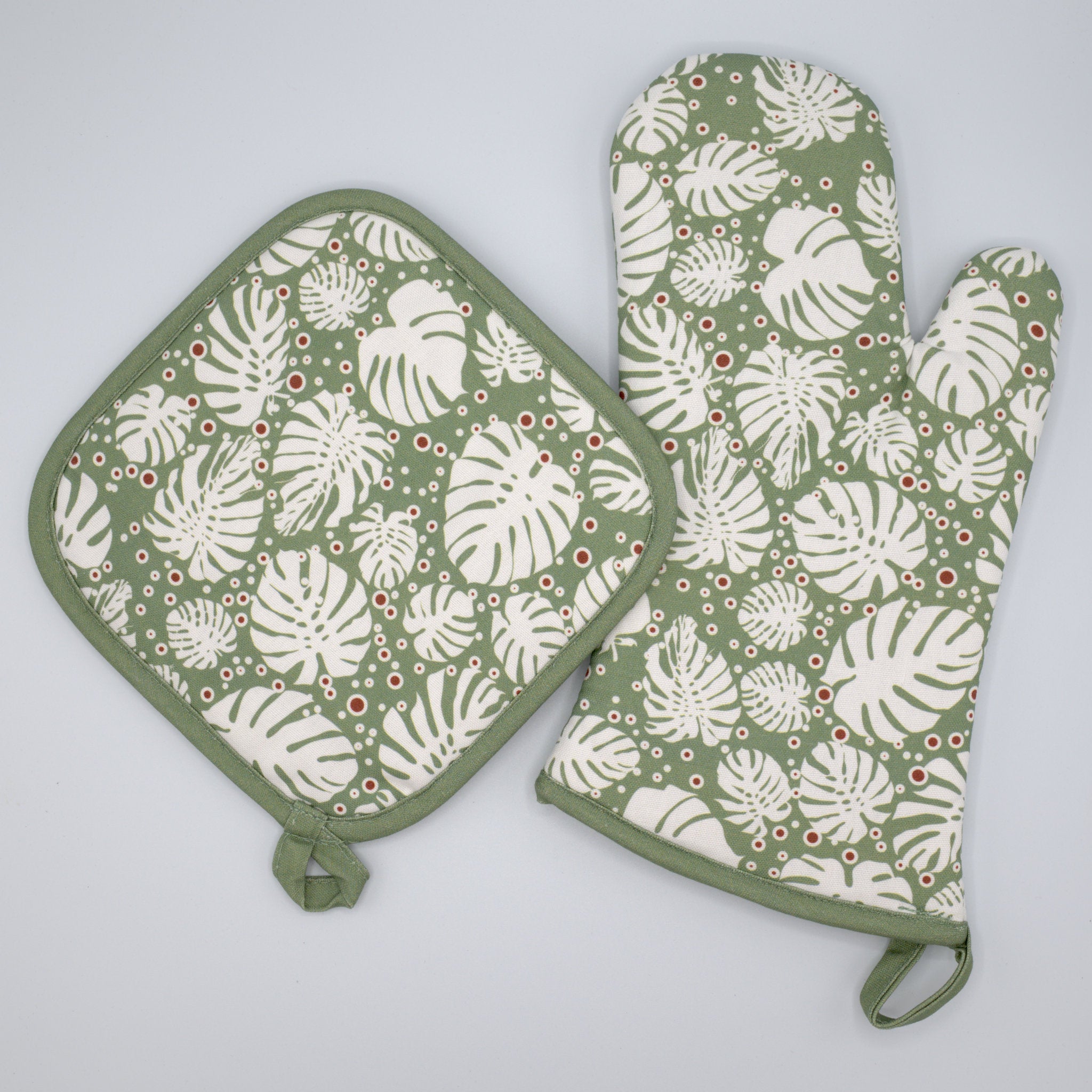 Set of green and white patterned oven mitt and pot holder on a light gray background from Hem And Tassel 
