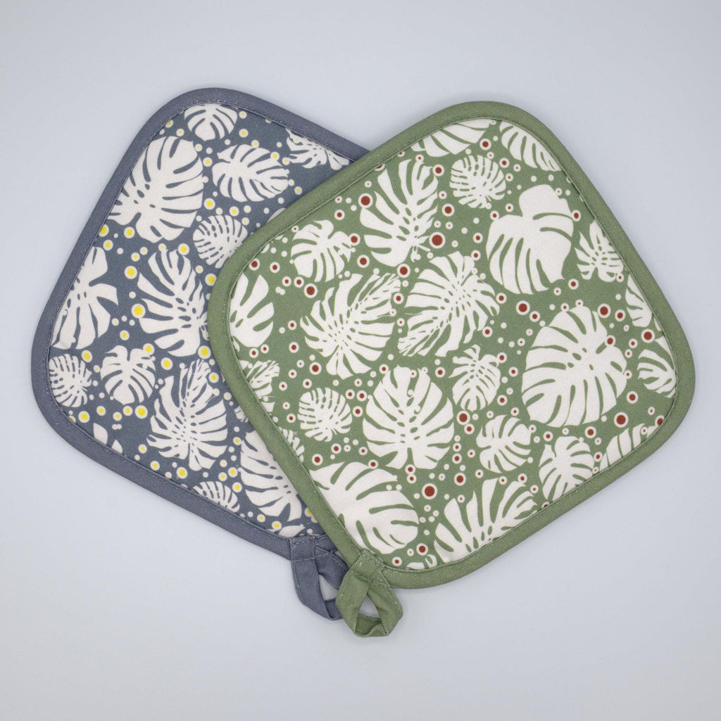 rich cotton quilted and pocketed pot holders in winter and turf colors of monster-ah design against a light grey backdrop - from Hem And Tassel