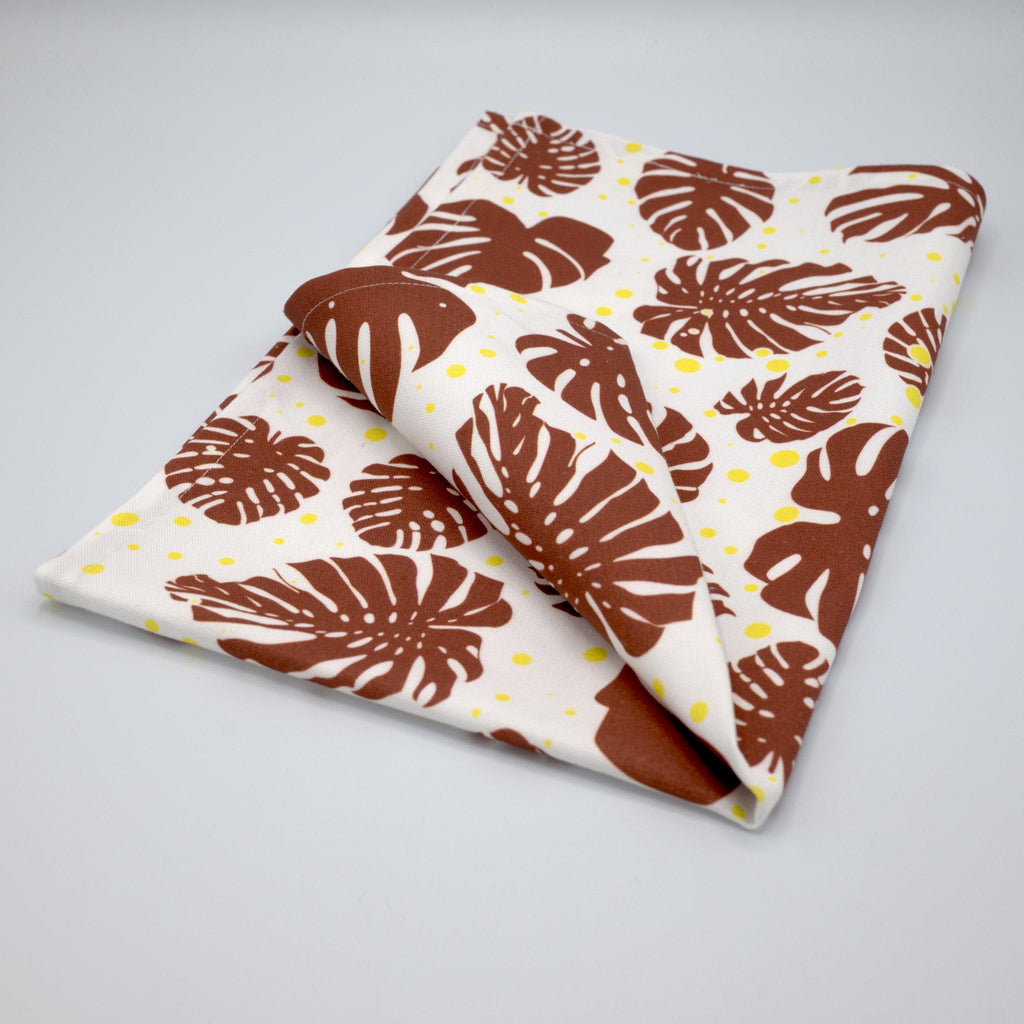 monster ah kitchen towel with brown leaf pattern folded on a light gray background from Hem And Tassel 