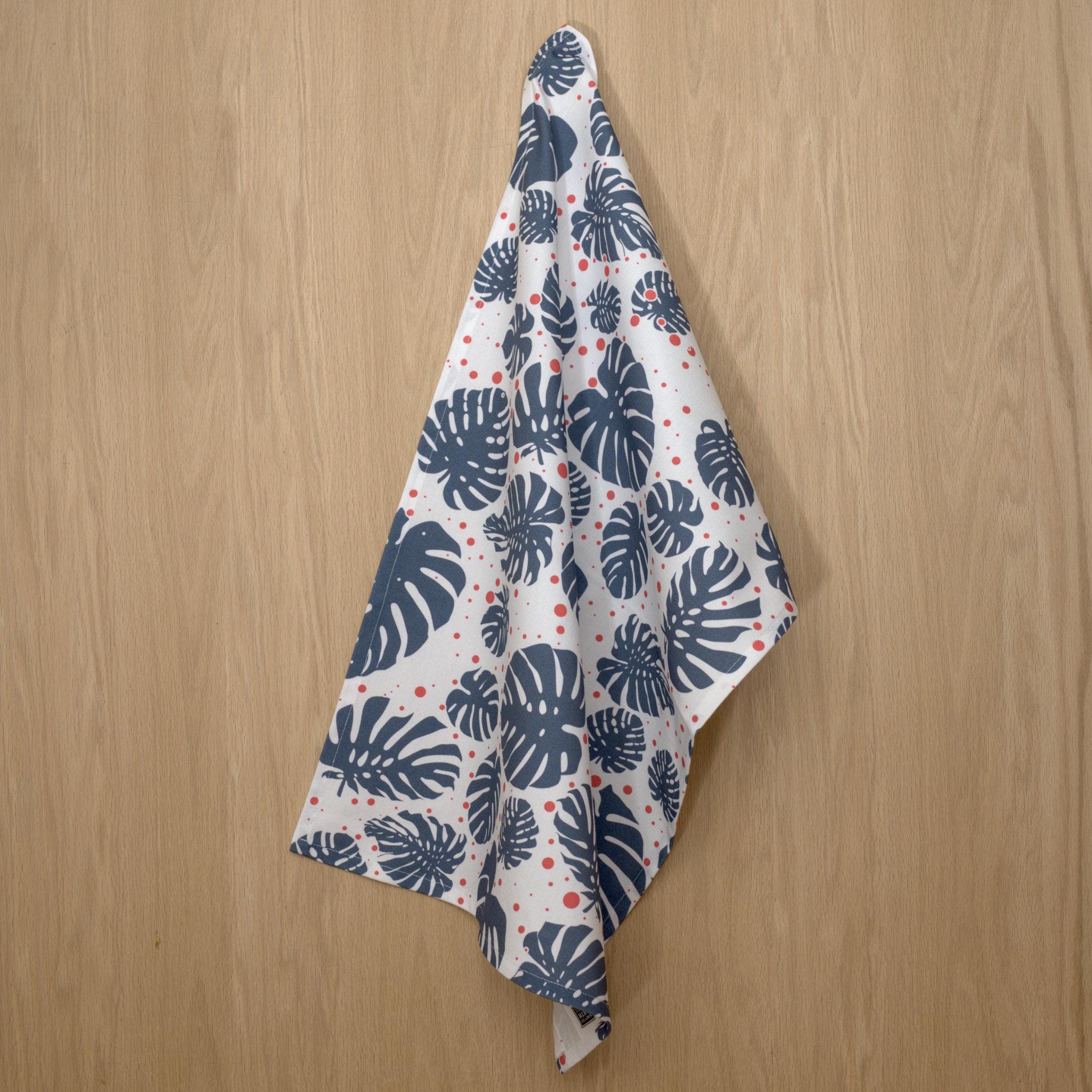 rich cotton percale kitchen towel of Monster-Ah design of oil and pink colors against wooden backdrop - from Hem And Tassel