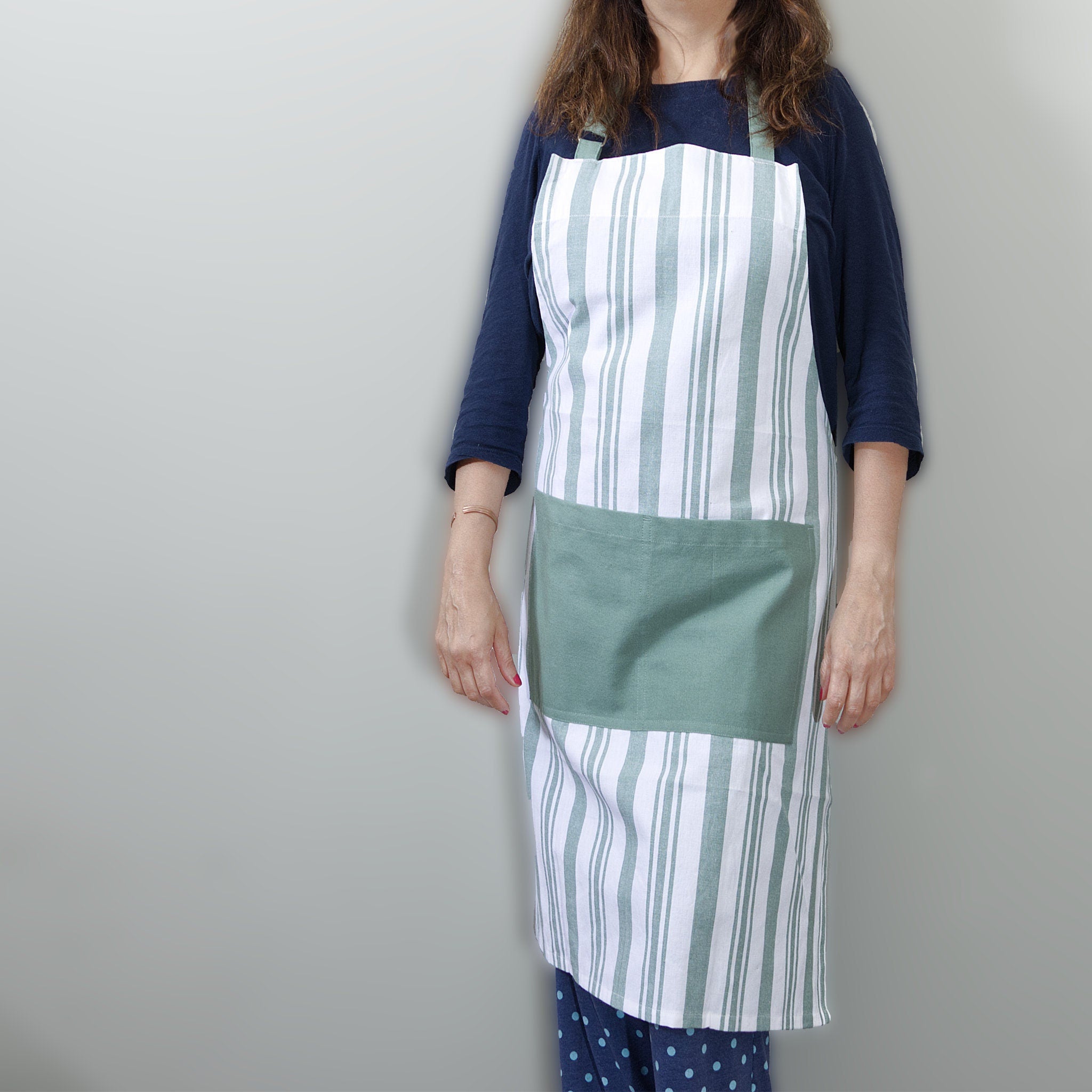decade classic striped cotton Apon in green stripes on white from Hem And Tassel on person  against a grey background
