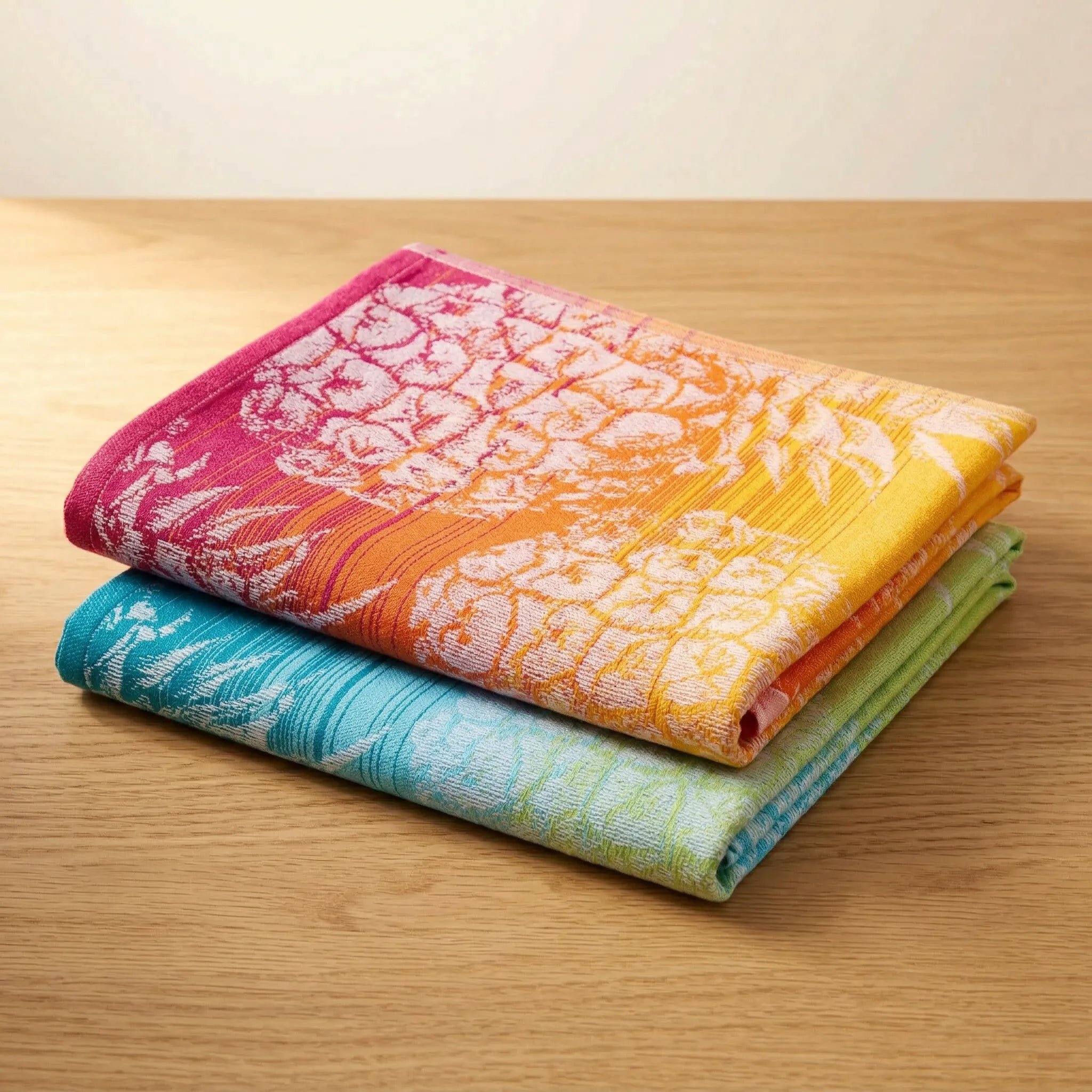 colorful jacquard kitchen towels of 100% cotton with a pineapple pattern - in a set of two folded and stacked on a wooden surface from Hem And Tassel