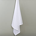 plain white flour sack hanging cotton towel on a grey background from Hem And Tassel 
