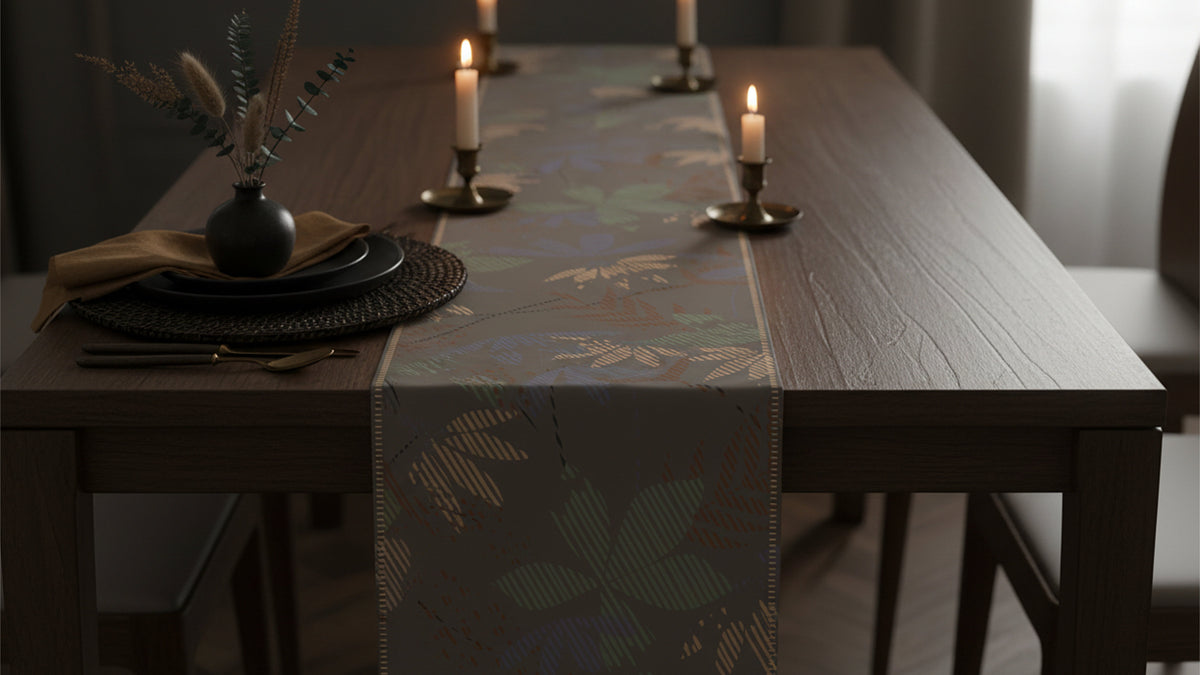 A dark wood dining table set with a patterned table runner, place settings, and lit candles in a dimly lit interior.