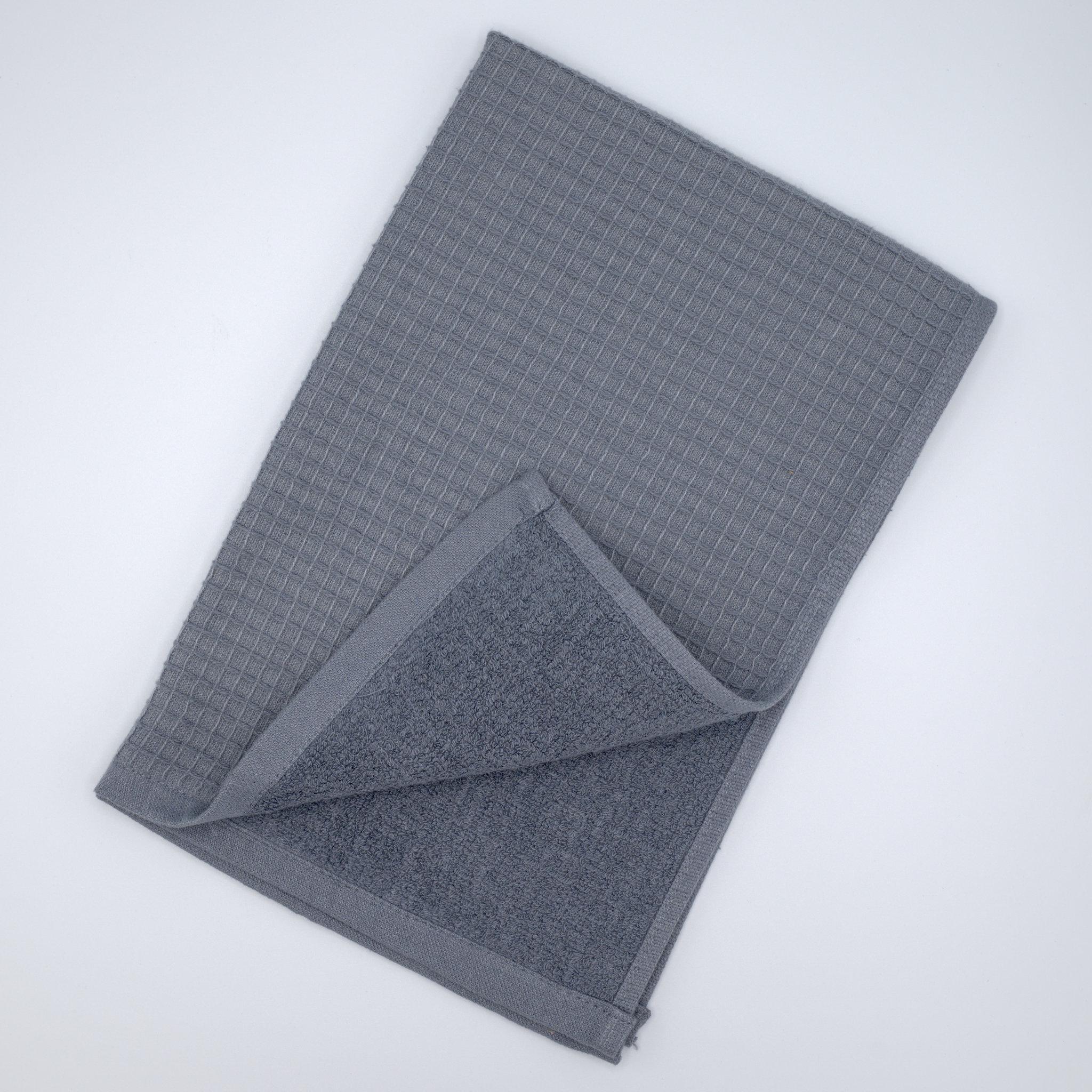 Folded grey Jekyll and Hyde kitchen towel on a gray background flipped open to see both surfaces of the towel