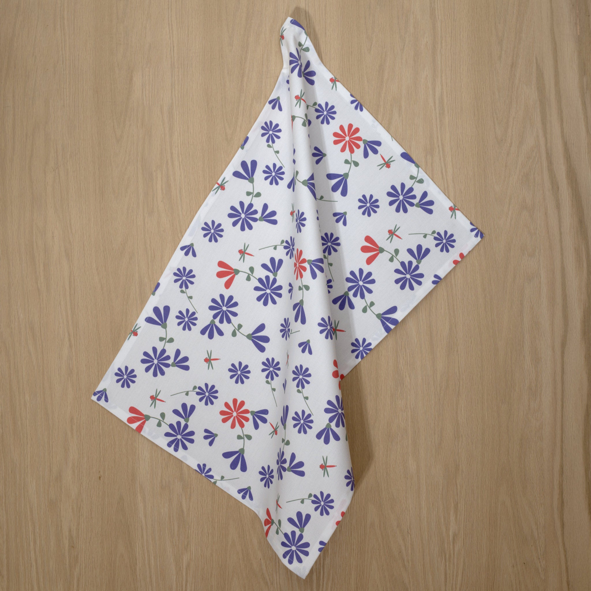purple and pink Floral patterned Shy Dragonfly kitchen towel on a wooden surface fff