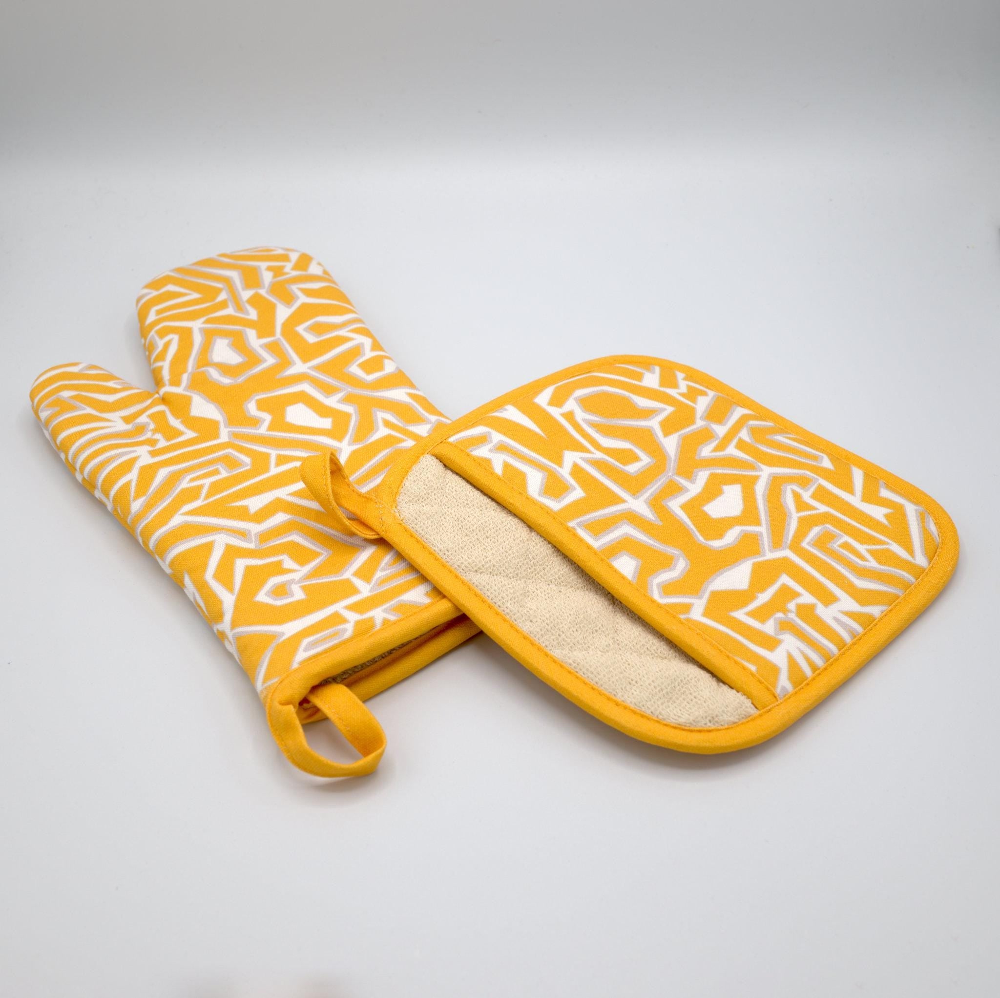 rich cotton oven mitt and pot holder in orange color of squiggles design against light grey backdrop - from Hem And Tassel