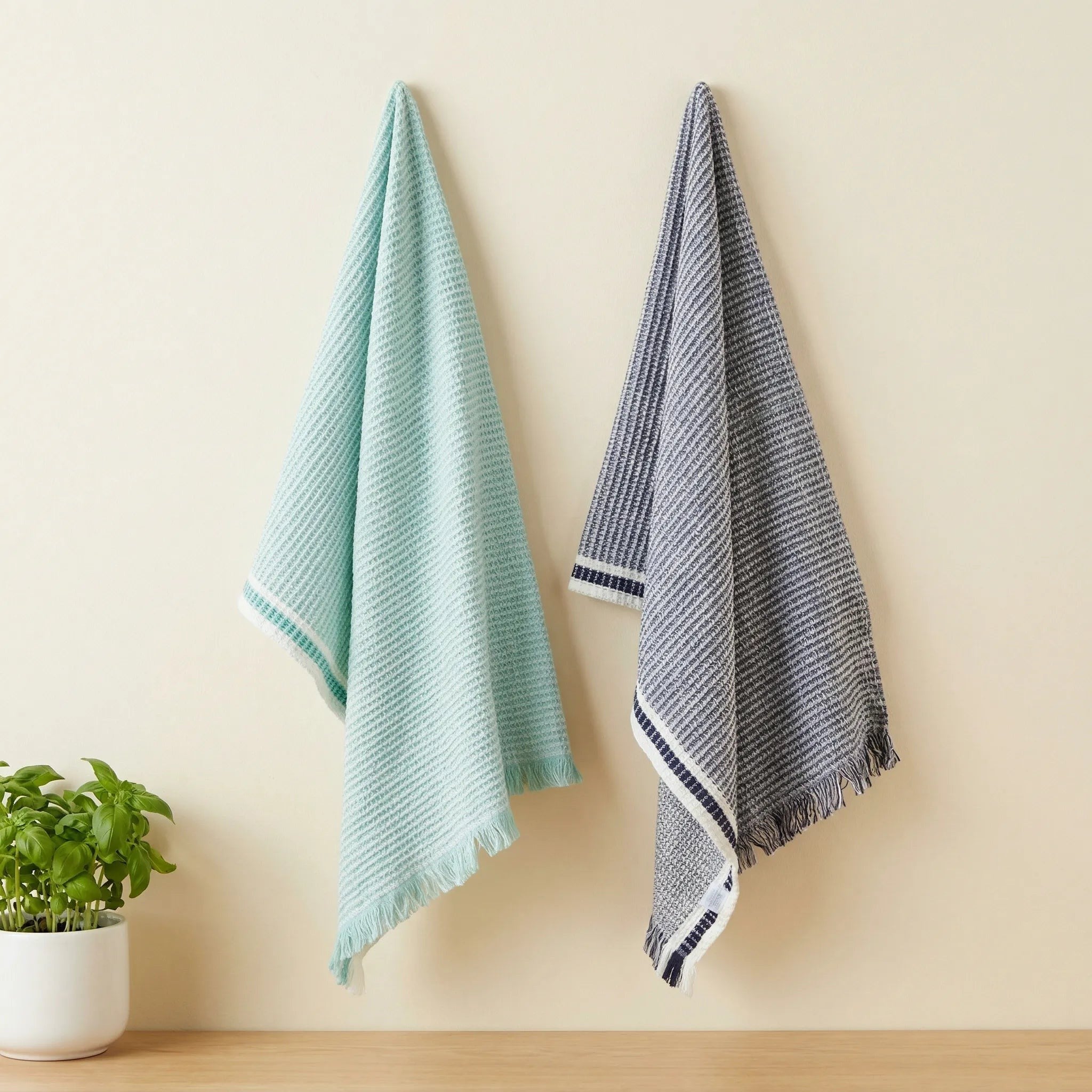 stonewashed waffle  - set of two 100% cotton kitchen towels in grass and cjarcpa;, hanging against a cream backdrop, from Hem And Tassel