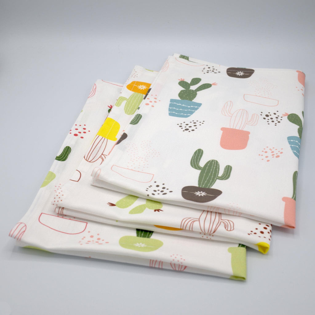 Stack of thorny issue kitchen towels with cactus pattern on a gray background from Hem And Tassel 