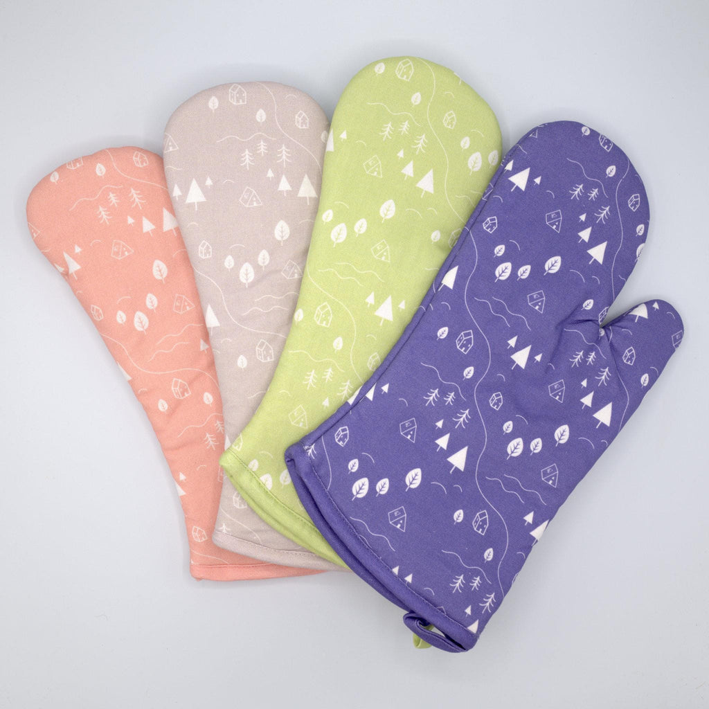 four cotton oven mitts of tiny countryside design in four colors with white pattern, on a light grey background, from Hem And Tassel 