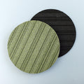 Two circular heatsink cork trivets, one green and one black, on a light blue background from Hem And Tassel 