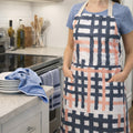 Person wearing a jute impossible checked pattern apron in a kitchen setting from Hem And Tassel 