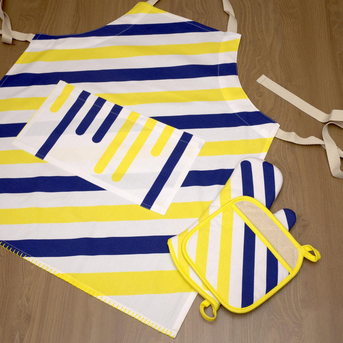 yellow piano design cotton apron apron, matching cotton oven mitt and pot holder on wood back ground from Hem And Tassel