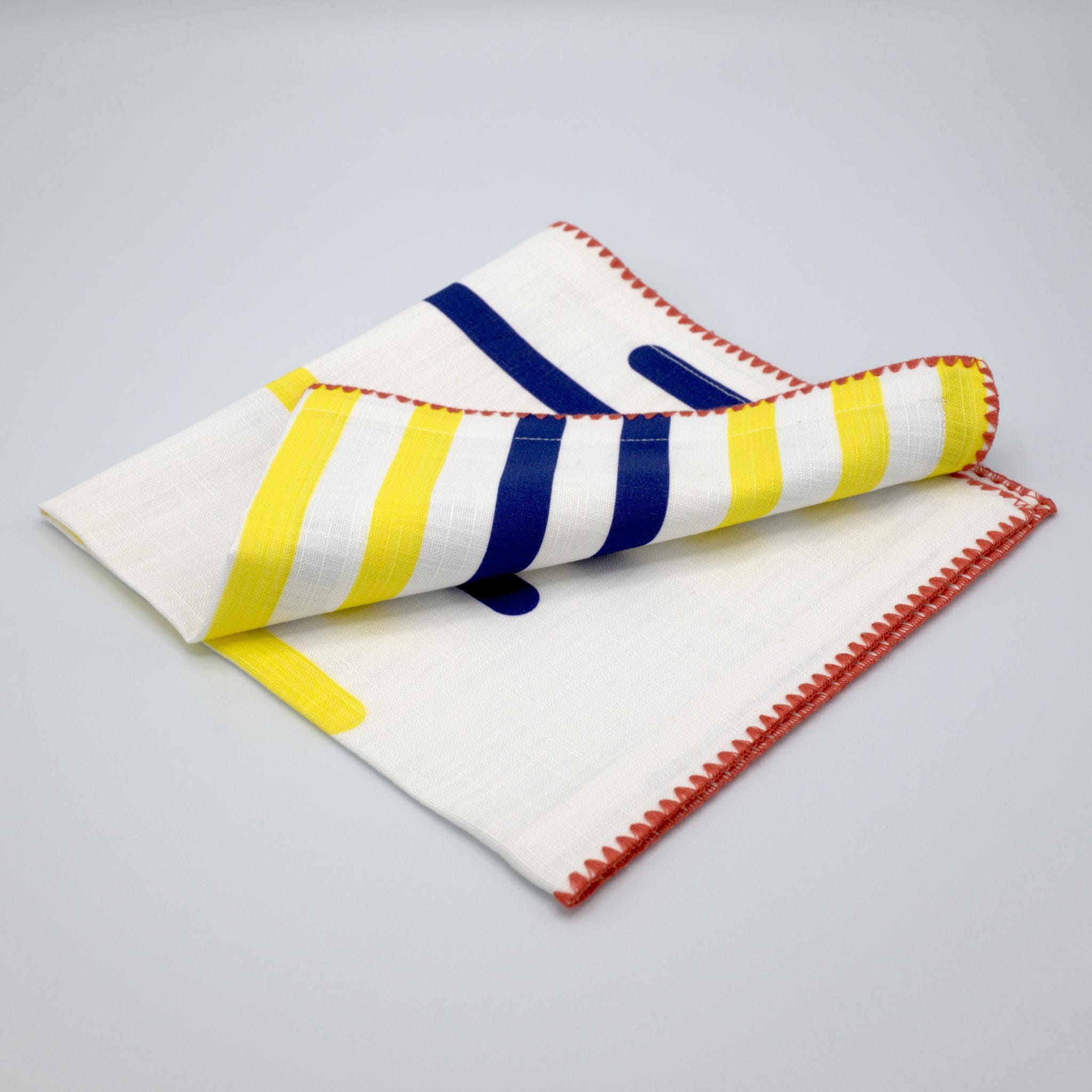 yellow piano cotton slub dinner napkin with red stitching from Hem And Tassel, on a light gray background