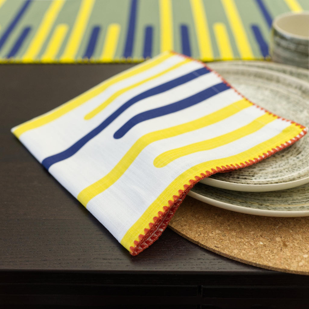 yellow piano table runner and yellow piano striped napkin on a table with plates and placemats from Hem And Tassel 