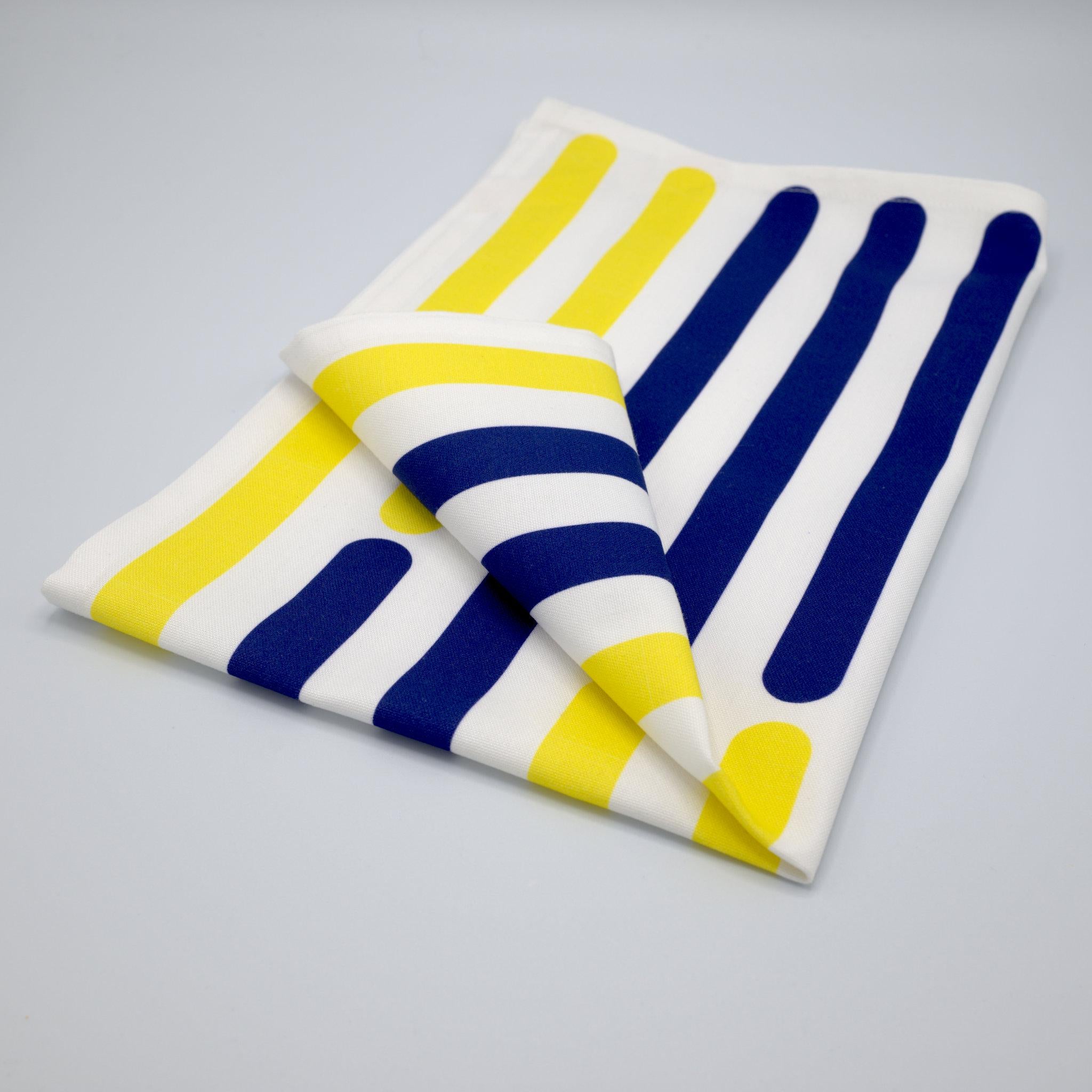 Folded yellow piano tea towel V with blue and yellow stripes on a gray background from Hem And Tassel 