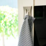 one reversible cotton towels in dark grey hanging on a loop with 3D checked side shown