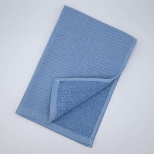 Jekyll and Hyde design tea towel in blue flat folded from hem and tassel