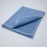 Jekyll and Hyde design tea towel in blue folded from hem and tassel