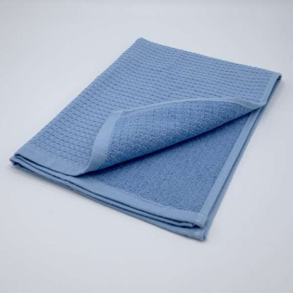 Jekyll and Hyde design tea towel in blue folded from hem and tassel