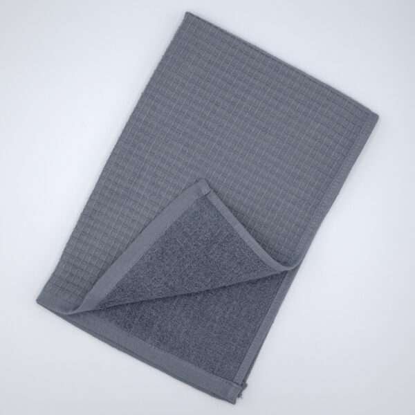 Jekyll and Hyde design tea towel in grey flat folded from hem and tassel