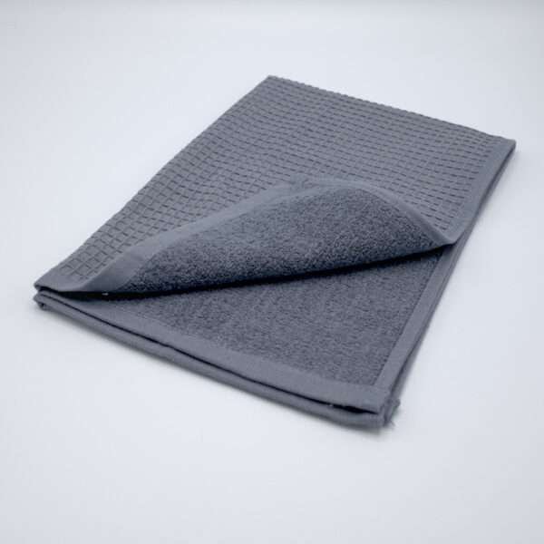 Jekyll and Hyde design tea towel in grey folded from hem and tassel