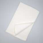 Jekyll and Hyde design tea towel in white flat folded from hem and tassel
