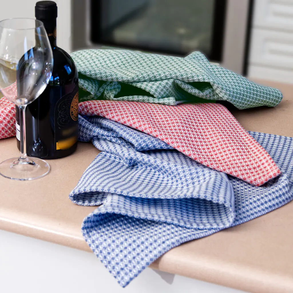 set of three colors of diamond waffle design on a kitchen counter seen with a bottle of wine and wine glass