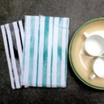 100% Cotton Towels set of 2 with distressed print stripes in green on one and black on the other
