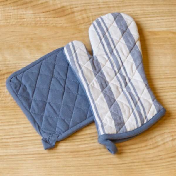 Quilted Decade classic oven mitt and pot holder shown in blue color on a wooden table