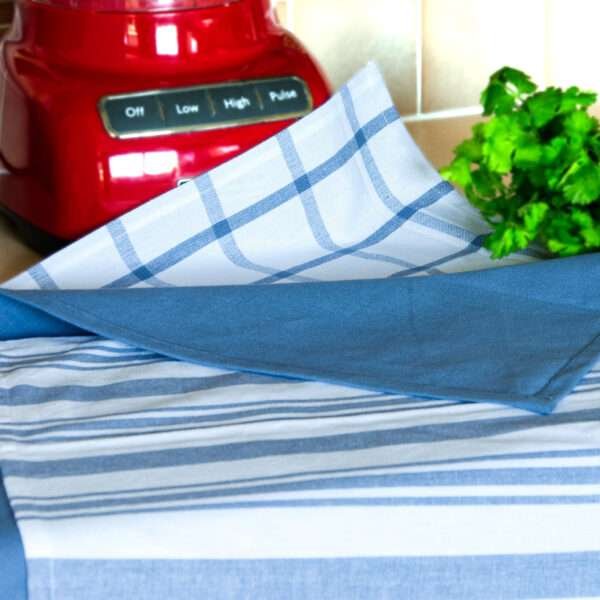 Decade classics tea towels in blue, shown on a table with all three styles clearly visible