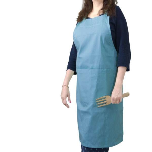 grill and drill Woman wearing, pro-grade, heavy duty, drill cotton cooking and baking Apron, in in oil blue with divided pocket and with adjustable neck straps