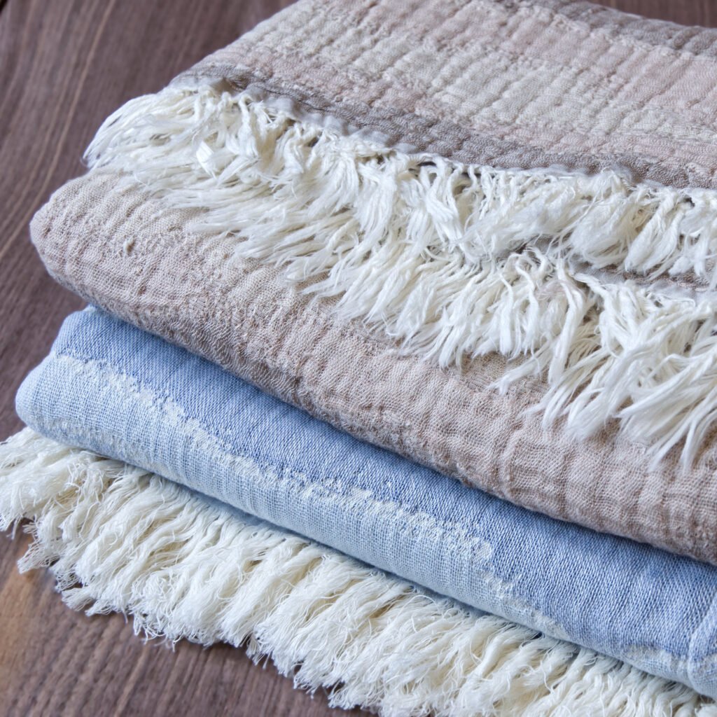 Throw From Europe 100% Cotton Gauze Waves throw beige and ocean color on wood close up