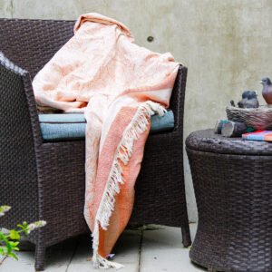 Throw From Europe 100% Cotton Reversible Jacquard Garden pattern in Rust color on outdoor garden chair