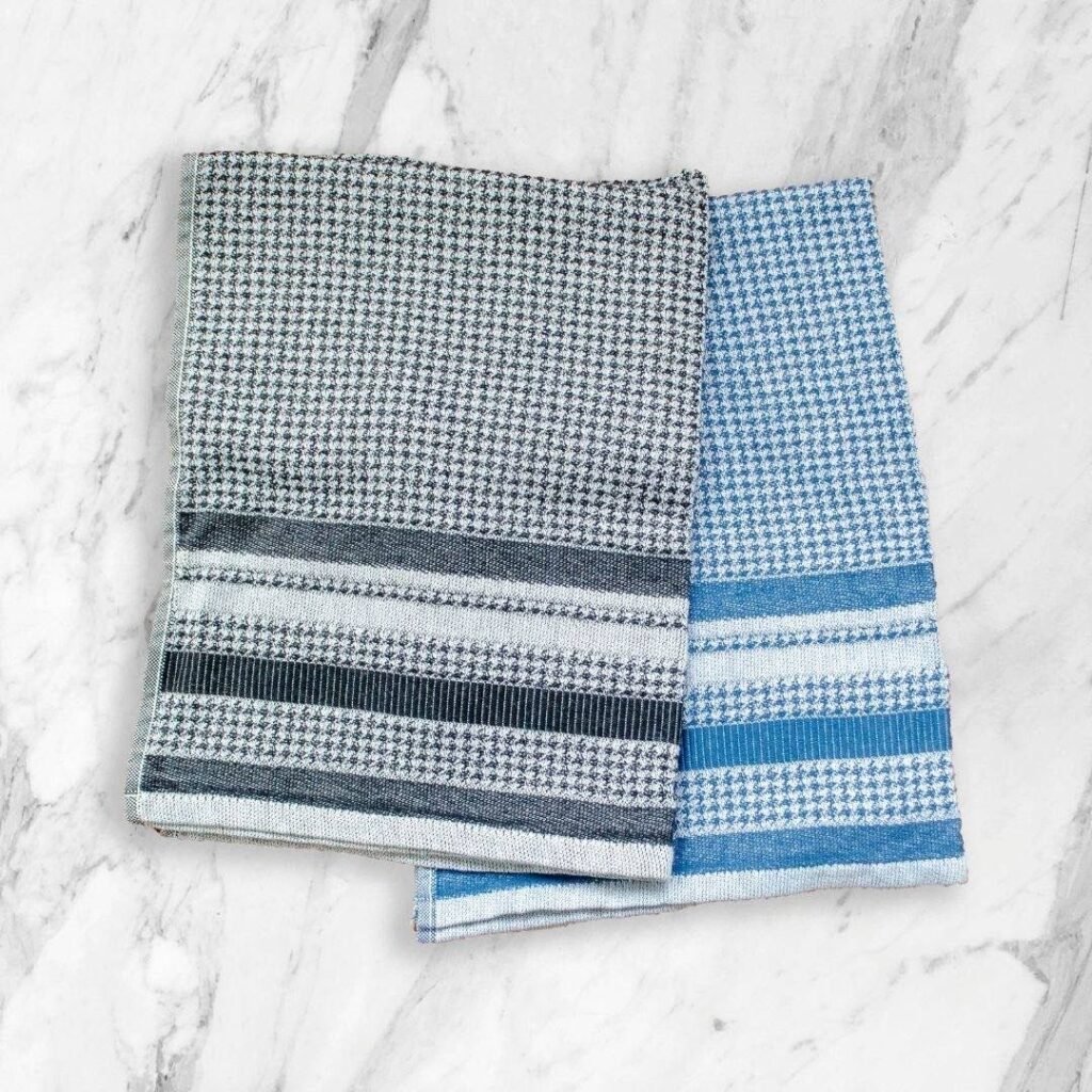 All over houndstooth pattern in flat Terry material. Tea towels in black and blue on counter