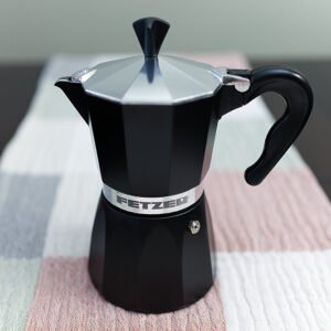 Lovely all-black Moka Pot with lid shut, on table runner