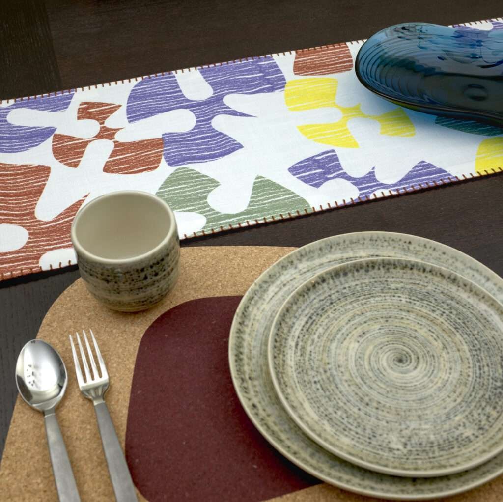 Flock and flutter design Shadow Runner LS looking down with clay kidney bean cork placemat from hem and tassel