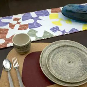 Flock and flutter design Shadow Runner LS looking down with clay kidney bean cork placemat from hem and tassel