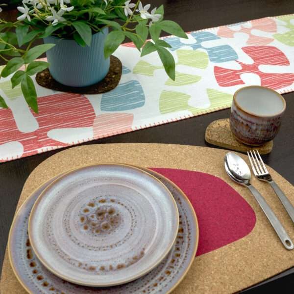 Flock and flutter design shine Runner LS looking down with pink kidney bean cork placemat from hem and tassel