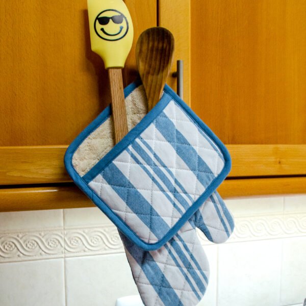 Quilted Decade classic oven mitt and pot holder shown in blue color, hanging with with striped side visible
