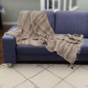 Pure cotton, Gauze throw in beige waves pattern on dark colored sofa