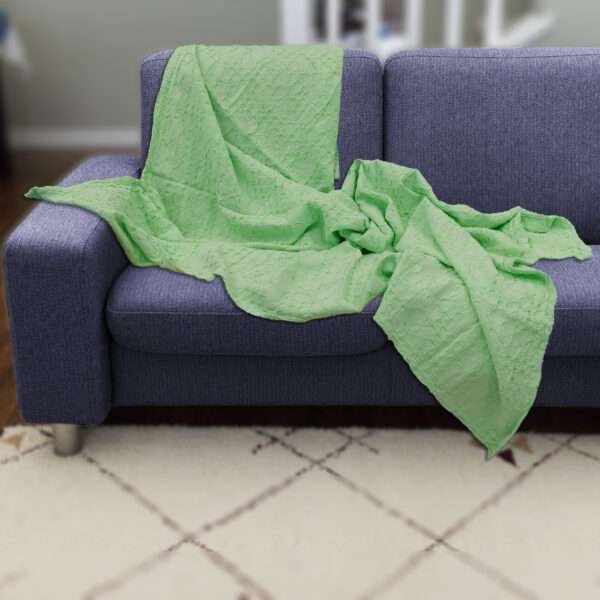 Pure cotton, box waffle throw in creamy pistachio color on dark sofa